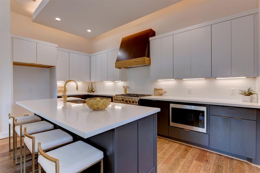 View of clean cabinetry and storage. Built-in microwave and high-end gas range. The kitchen features modern appliances and ample storage solutions, perfect for culinary enthusiasts and those who value organization.