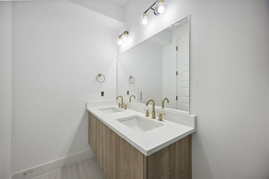 Experience contemporary elegance with this sleek main-floor bathroom, featuring a chic double vanity, stylish lighting, and a spacious mirror to enhance your daily routine.