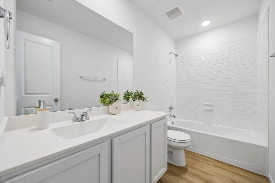 Full bath with vanity, light wood finished floors, and shower / bath combination