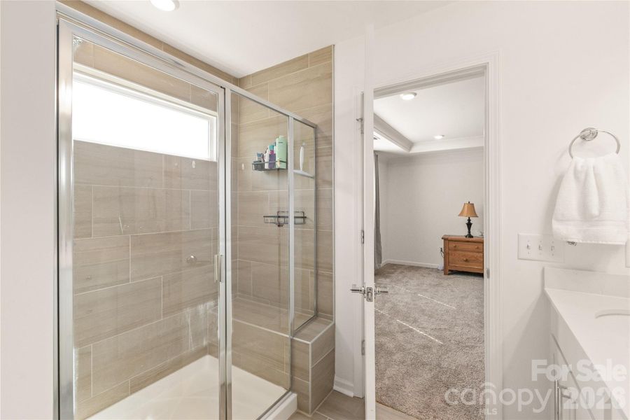 Oversized walk-in shower with floor to ceiling tile and bench seat