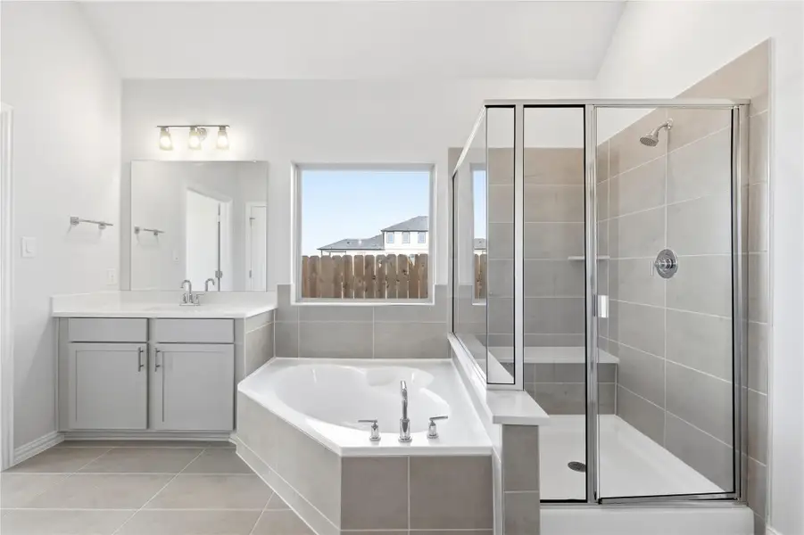 Bathroom featuring a bath, vanity, a shower stall, and light tile patterned floors Bathroom featuring a bath, vanity, a shower stall, and light tile patterned floors