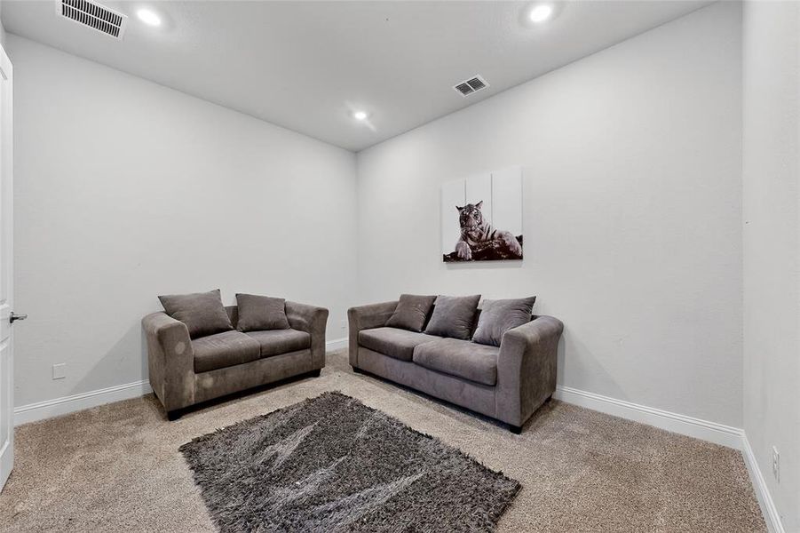 Living room with light colored carpet and recessed lighting