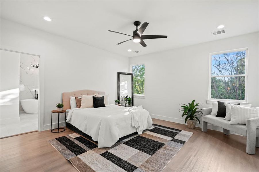Bedroom with wood finished floors, recessed lighting, ensuite bath, and ceiling fan