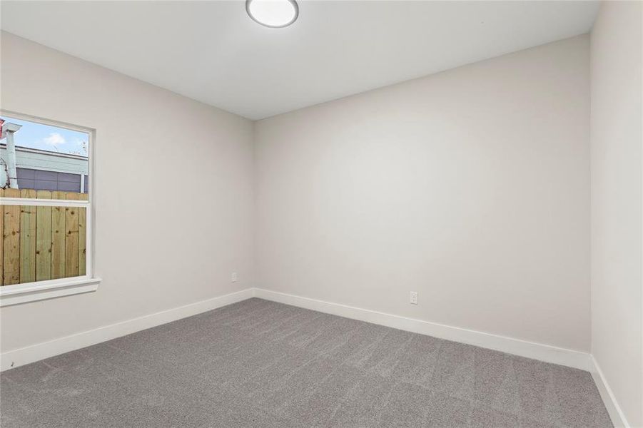 Carpeted spare room with baseboards