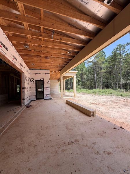 Spacious under-construction patio with a rustic wooden ceiling, offering serene views of the surrounding wooded area. Spacious under-construction patio with a rustic wooden ceiling, offering serene views of the surrounding wooded area.