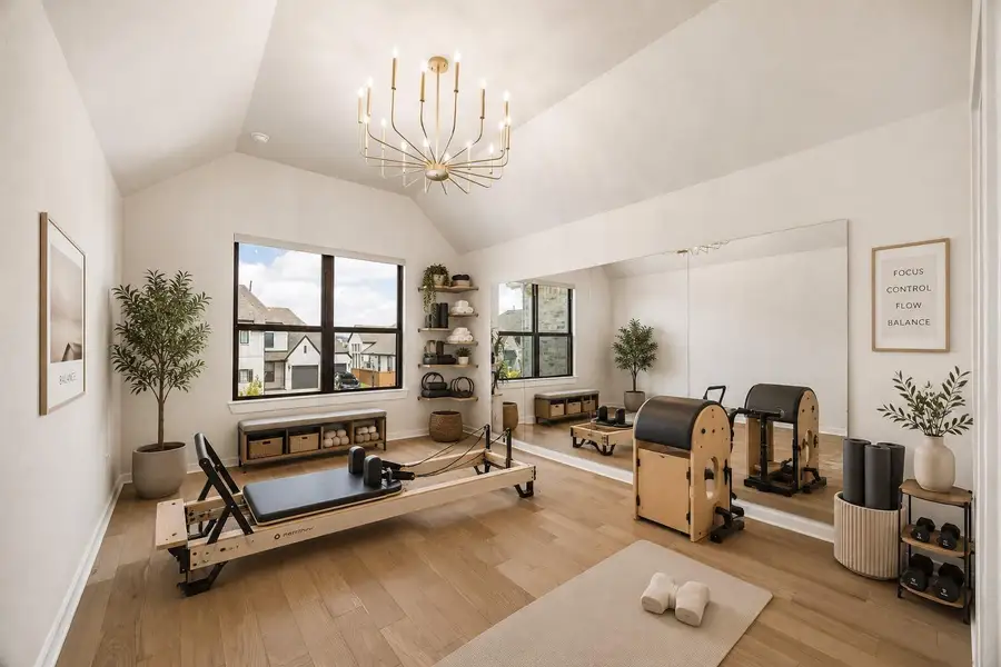 BEDROOM 3 - USED HERE AS A FLEX ROOM FEATURES A VAULTED CEILING, GORGEOUS CHANDELIER, LARGE WINDOW, WOOD FLOORING, AND A FULL MIRRORED WALL, MAKING IT WELL SUITED FOR FITNESS OR STUDIO USE. **Virtually Staged. BEDROOM 3 - USED HERE AS A FLEX ROOM FEATURES A VAULTED CEILING, GORGEOUS CHANDELIER, LARGE WINDOW, WOOD FLOORING, AND A FULL MIRRORED WALL, MAKING IT WELL SUITED FOR FITNESS OR STUDIO USE. **Virtually Staged.