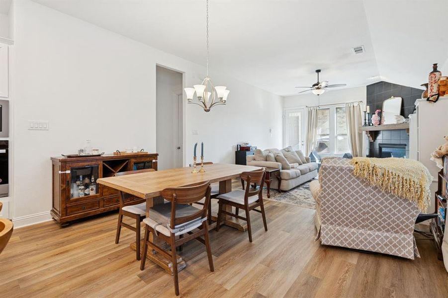 Dining space featuring light wood finished floors, a chandelier, and a ceiling fan Dining space featuring light wood finished floors, a chandelier, and a ceiling fan