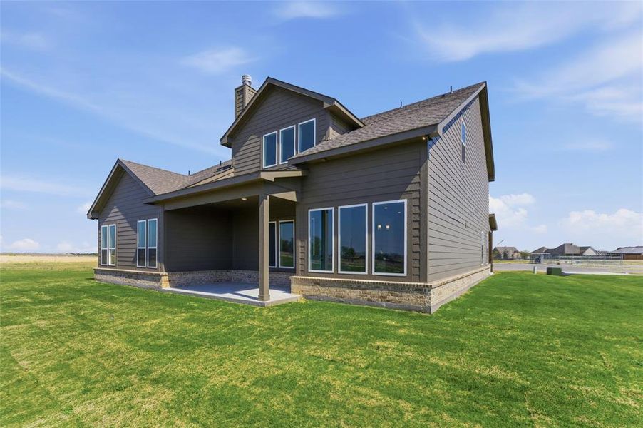 Rear view of house featuring a yard, a patio area, a chimney, a shingled roof, and brick siding Rear view of house featuring a yard, a patio area, a chimney, a shingled roof, and brick siding