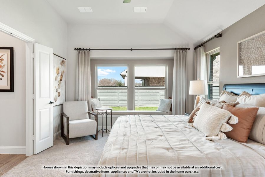 Bedroom with vaulted ceiling, large windows, sitting area, and blue upholstered headboard