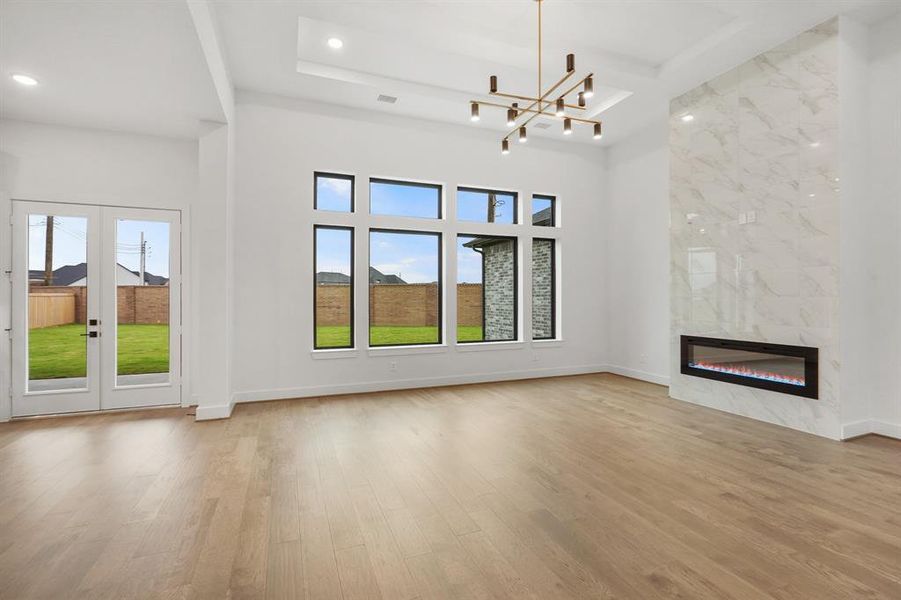 SAMPLE Modern electric fireplace and coffered 15' ceilings make this family room the perfect gathering place!