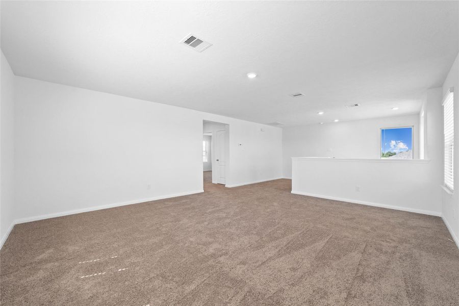 Another perspective of the Loft, showcasing the staircase and hallway leading to the secondary bedrooms.