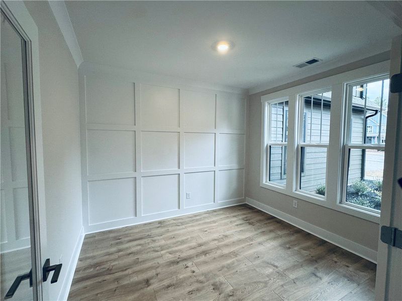This versatile room features elegant wainscoting a