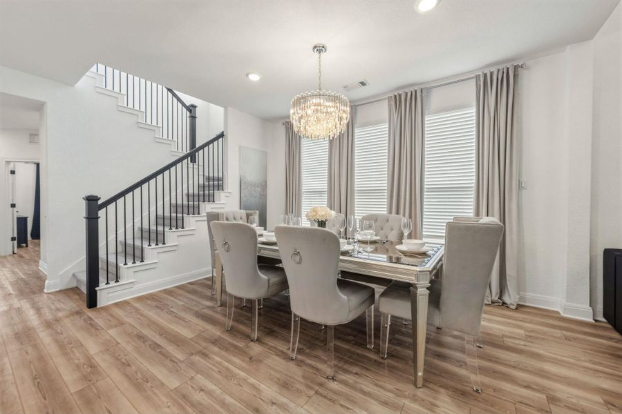 Open-concept living space featuring, recessed lighting, a crystal chandelier with blinds