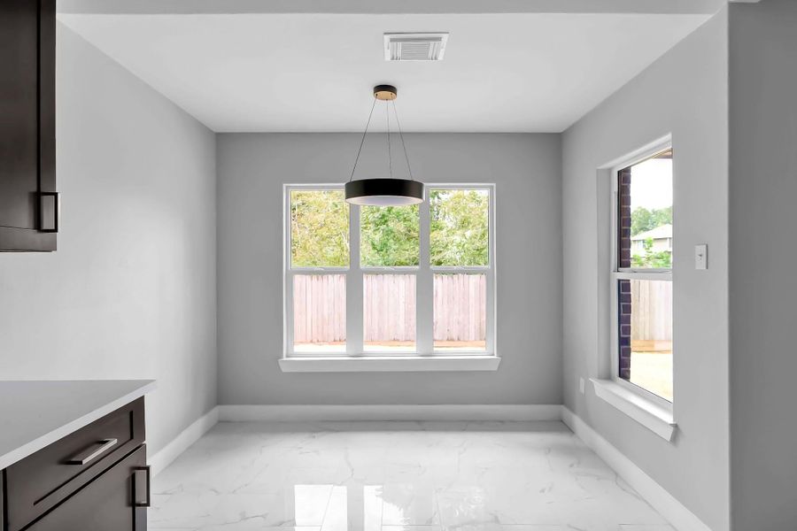 Bright dining area with large windows offering natural light, modern light fixture, and sleek tile flooring. Neutral gray walls create a contemporary feel. Perfect for casual dining. Bright dining area with large windows offering natural light, modern light fixture, and sleek tile flooring. Neutral gray walls create a contemporary feel. Perfect for casual dining.