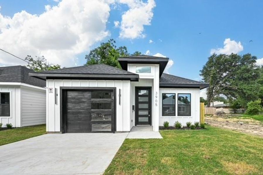 Prairie-style home featuring a front yard and a garage