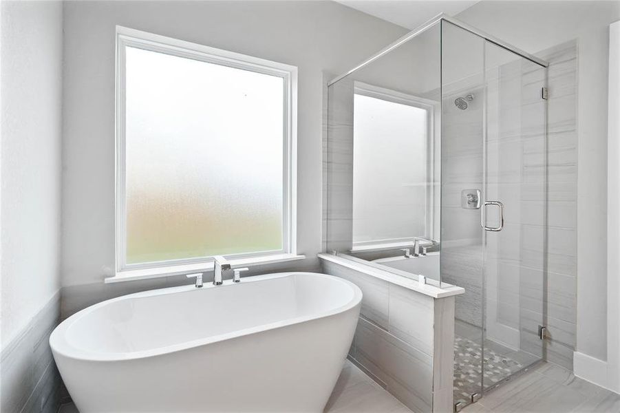 This additional view of the primary bath showcases the walk-in shower with tile surround and separate garden tub perfect for soaking after a long day.