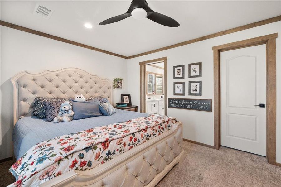 Bedroom with light carpet, connected bathroom, and ceiling fan Bedroom with light carpet, connected bathroom, and ceiling fan