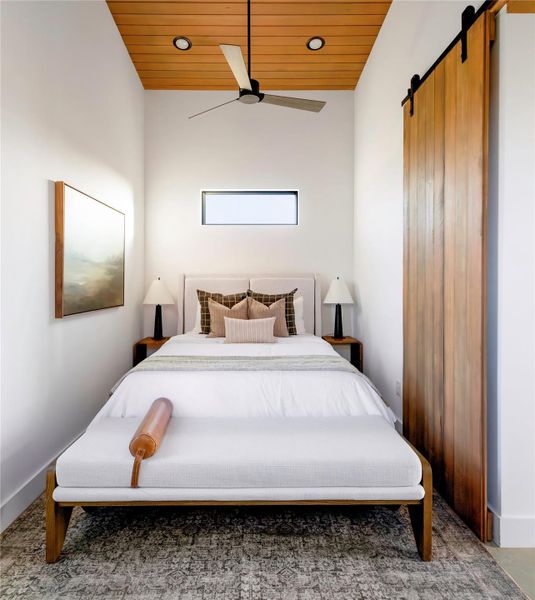 Cozy bedroom retreat with warm wood ceiling detail, designer finishes, and minimalist modern styling. Cozy bedroom retreat with warm wood ceiling detail, designer finishes, and minimalist modern styling.