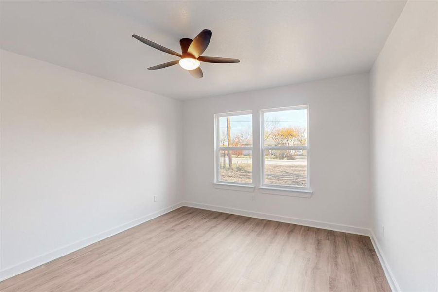 Unfurnished room featuring ceiling fan and light wood-type flooring