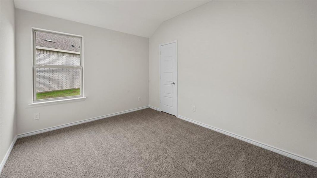 Carpeted interior room featuring a single window, white trim, and a paneled door