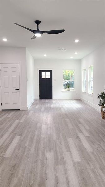 Unfurnished living room featuring light hardwood / wood-style floors and ceiling fan