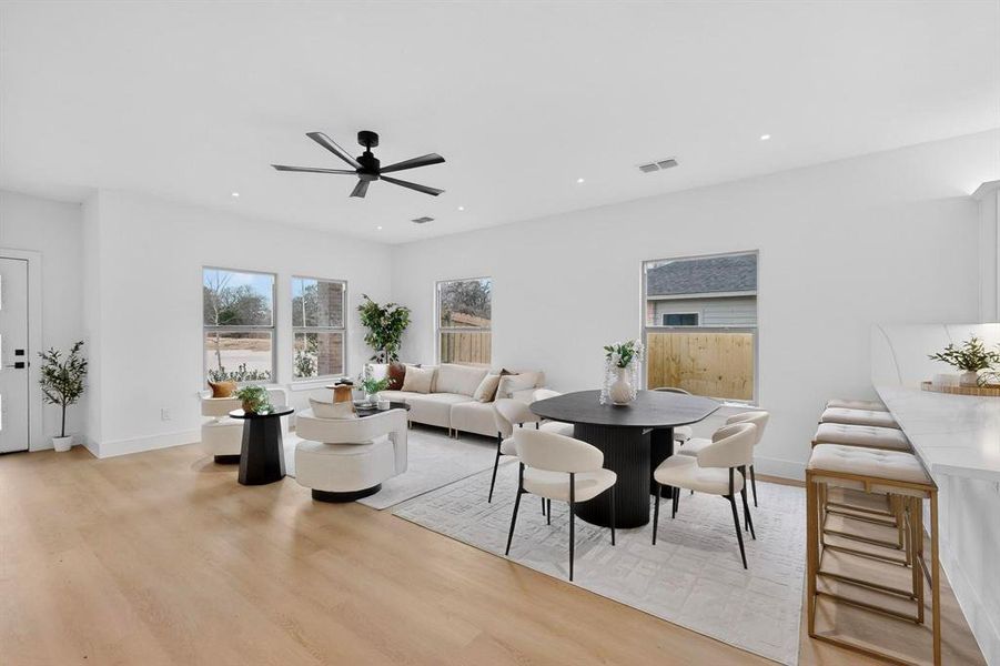 Dining space featuring light wood-type flooring, a ceiling fan, and recessed lighting