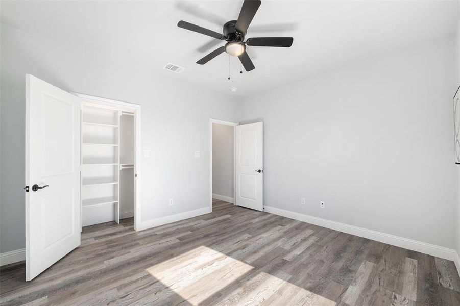 Unfurnished bedroom with light hardwood / wood-style flooring, a closet, and ceiling fan