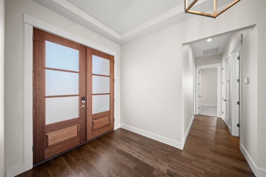 Entrance foyer with dark wood-style flooring and french doors