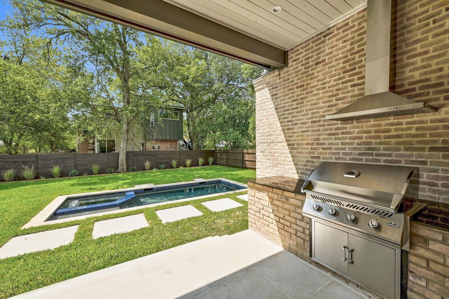 Built-in grill and custom countertops at rear patio.
