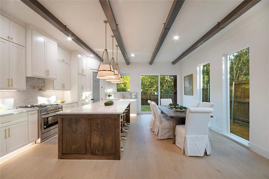 Kitchen with backsplash, white cabinetry, stainless steel gas stove, a kitchen island, and beamed ceiling