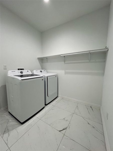 Washroom with separate washer and dryer, baseboards, marble finish floor, and laundry area Washroom with separate washer and dryer, baseboards, marble finish floor, and laundry area