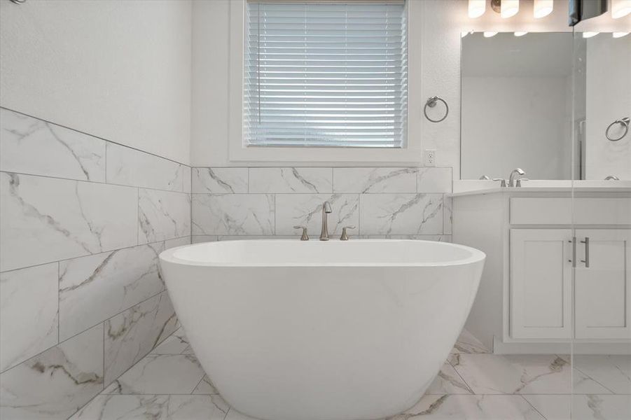 Beautiful Primary Bathroom with a 42"  freestanding tub & separate shower, featuring Moen faucets, designer ceramic tile walls and flooring.