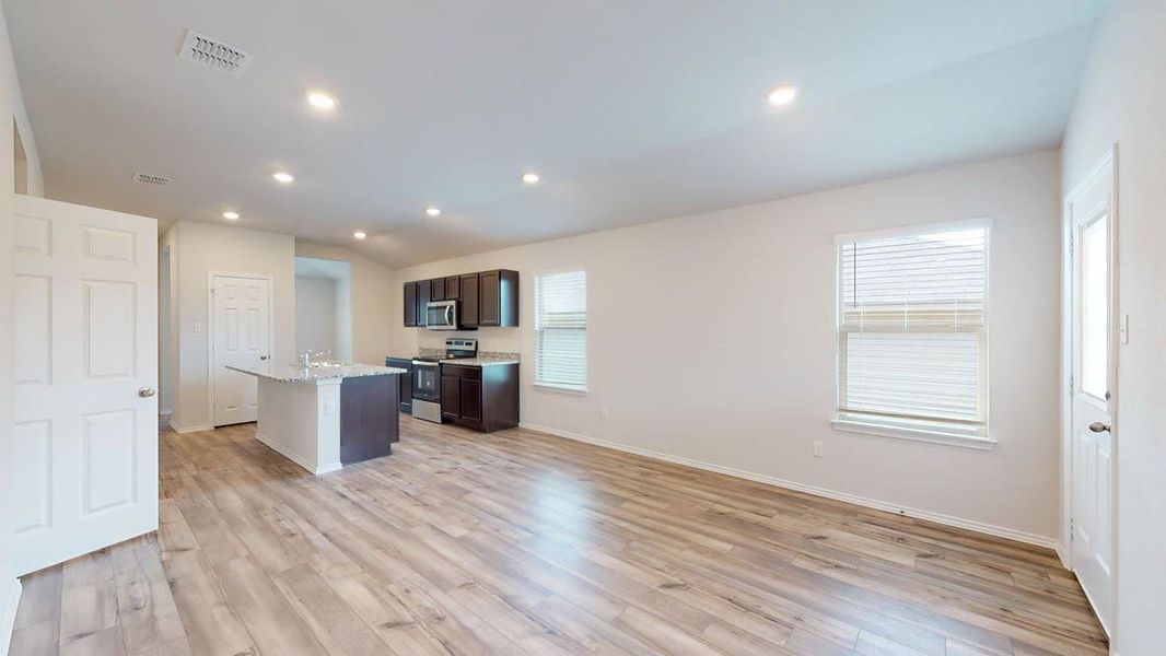 Open-concept living area with wood-finish flooring, recessed lighting, and white walls