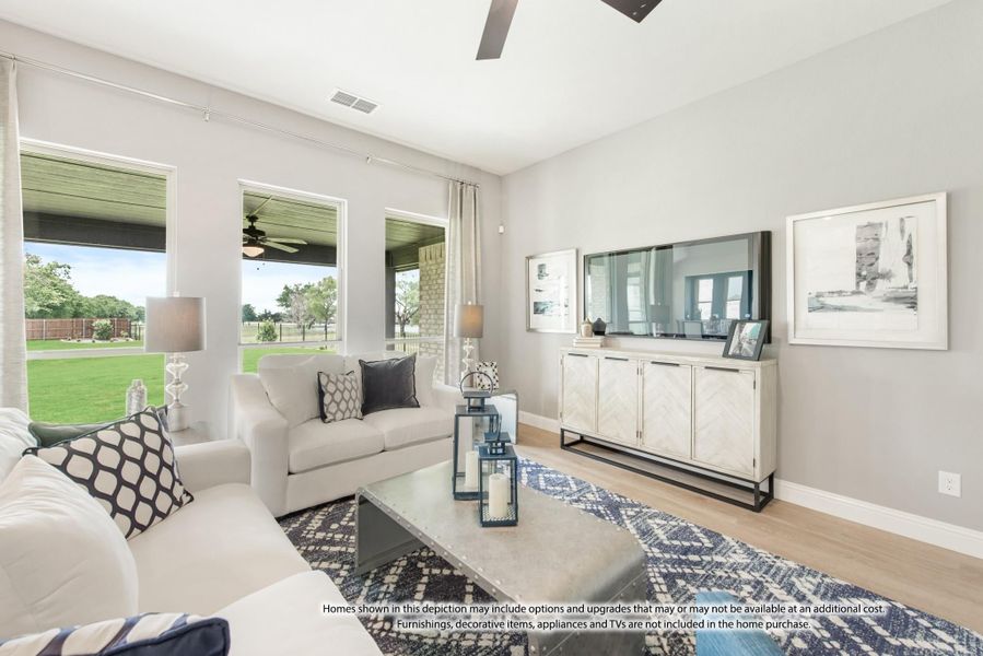 Living room with white sofas, hardwood floors, ceiling fan, and large windows overlooking a backyard patio Living room with white sofas, hardwood floors, ceiling fan, and large windows overlooking a backyard patio