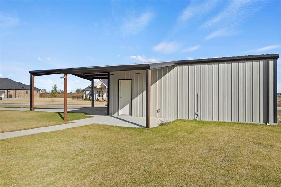 View of outdoor structure featuring a yard