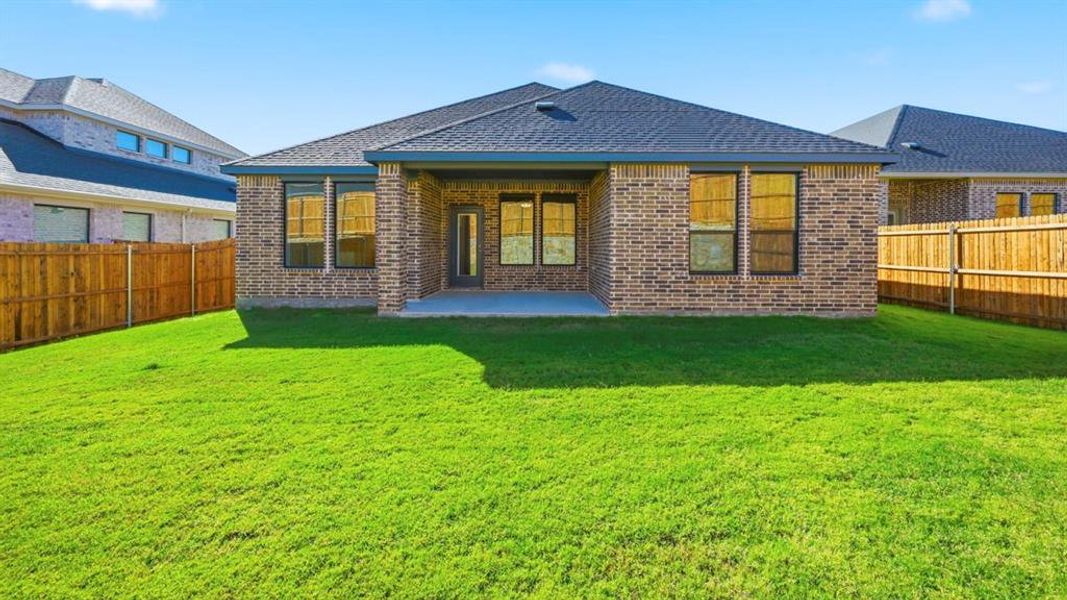 Back of property featuring a fenced backyard, a patio area, brick siding, and roof with shingles