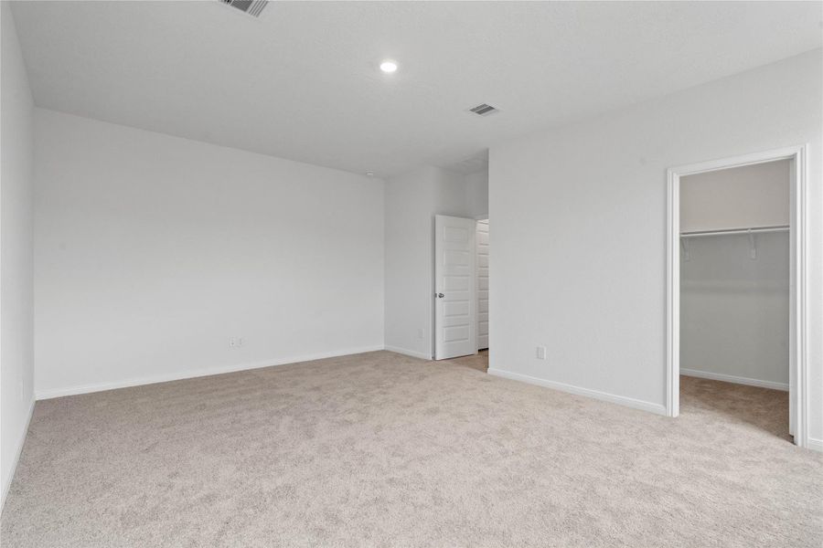 View of primary bedroom looking towards walk-in closet and ensuite bathroom. View of primary bedroom looking towards walk-in closet and ensuite bathroom.