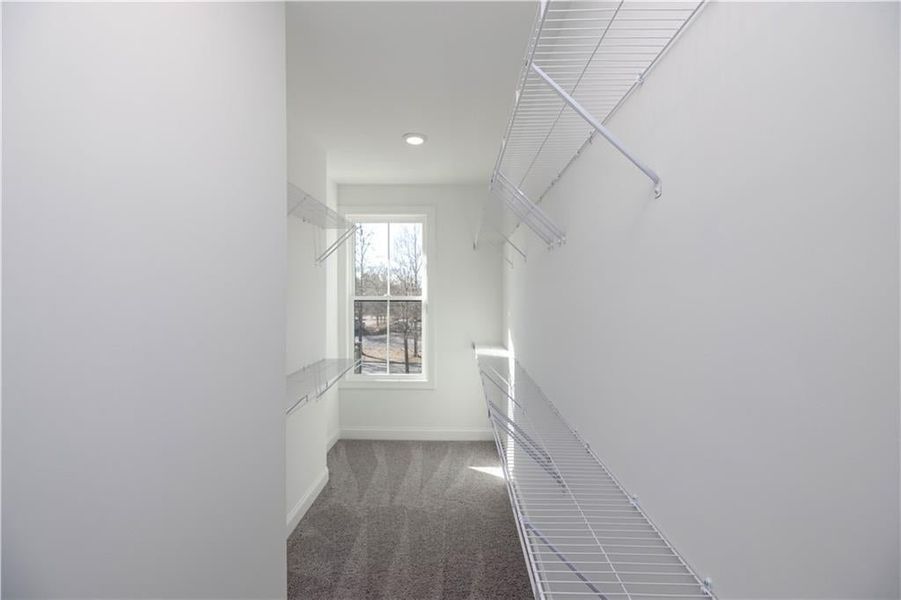 The primary closet is quite spacious and has a window to let in some natural light.