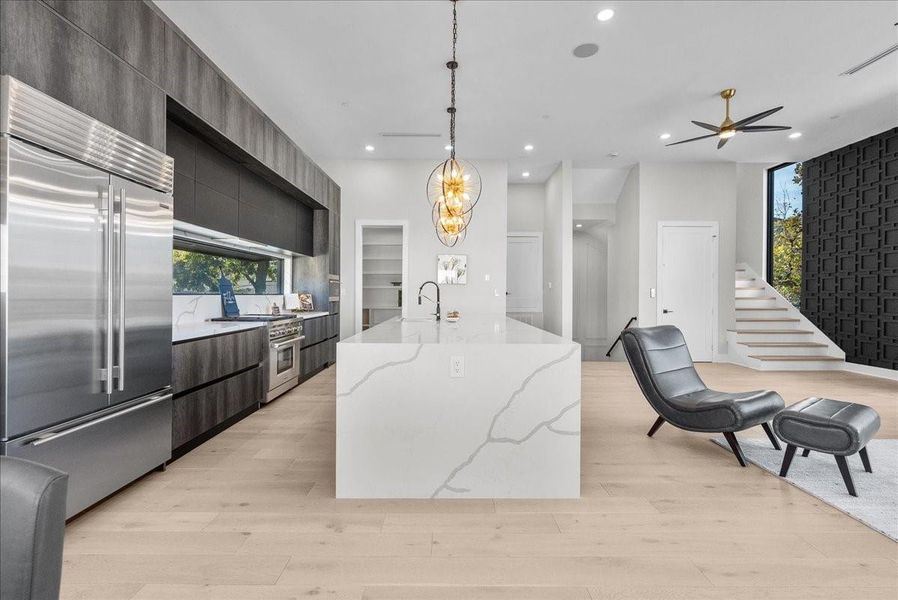 The oversized waterfall island offers generous prep space and seating for at least six, creating a true centerpiece for gathering and entertaining. The oversized waterfall island offers generous prep space and seating for at least six, creating a true centerpiece for gathering and entertaining.