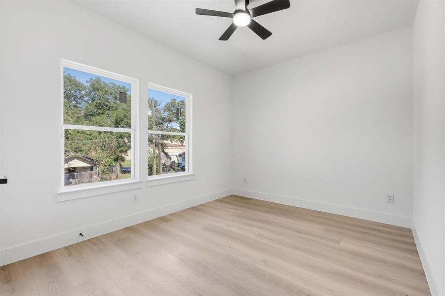 Empty room featuring light wood-style flooring and a ceiling fan