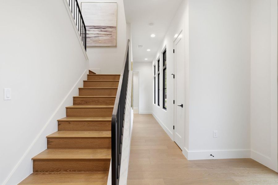Stairs with wood finished floors and recessed lighting