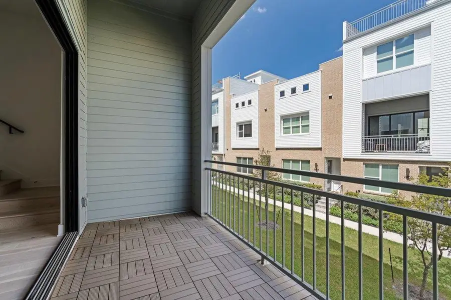 A private covered balcony features durable interlocking deck tiles and metal railings overlooking the neighborhood. A private covered balcony features durable interlocking deck tiles and metal railings overlooking the neighborhood.