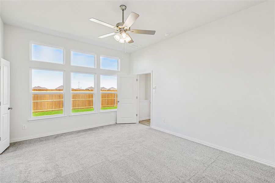 Carpeted empty room featuring ceiling fan