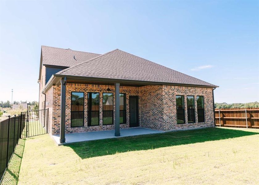 Rear view of property with a lawn and a patio