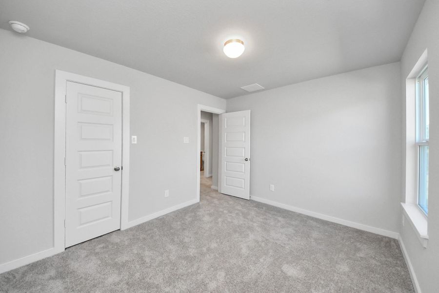 Generously sized secondary bedrooms featuring spacious closets, soft and inviting carpeting underfoot, large windows allowing plenty of natural light, and the added touch of privacy blinds for your personal retreat. Sample photo of completed home with similar floor plan. Actual colors and selections may vary.
