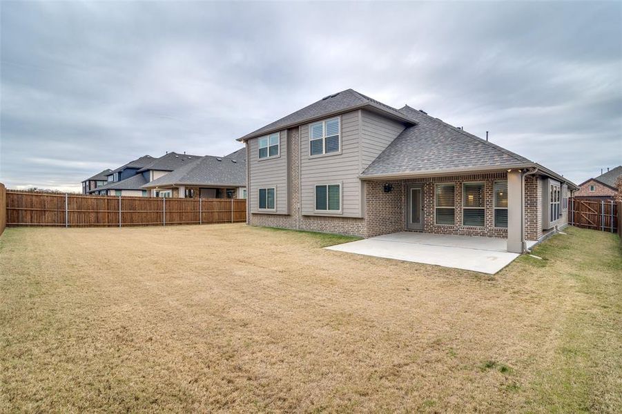 Back of house featuring an expanded patio, and a large backyard.