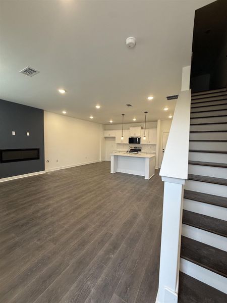 Unfurnished living room featuring dark wood-style floors and recessed lighting