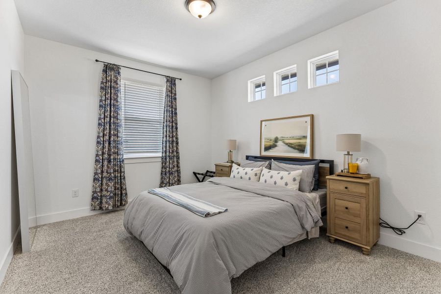 High clerestory windows and soft carpeting enhance this tranquil bedroom space.