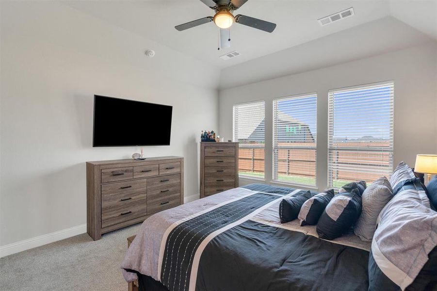 Carpeted room featuring a ceiling fan with integrated lighting, three windows with blinds, and white walls