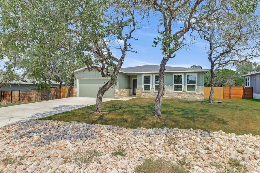 View of front of property featuring concrete driveway, an attached garage, trees, and landscaping View of front of property featuring concrete driveway, an attached garage, trees, and landscaping
